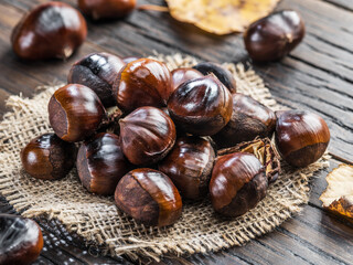 Roasted edible chestnut fruits on wooden table.