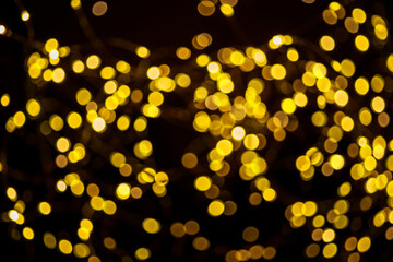 Blurred christmas lights on on dark background as a symbol of Christmas or New Year mystery and magic. Christmas background.