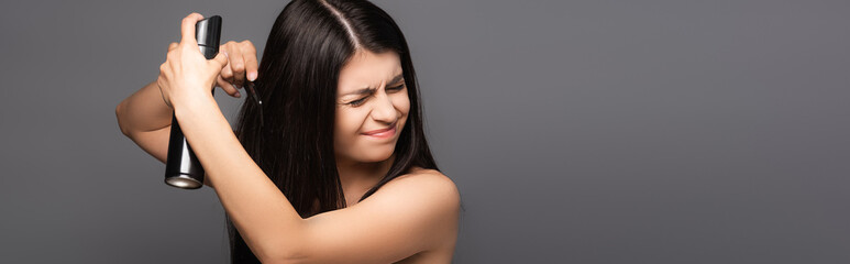 Fototapeta premium naked brunette long haired woman applying hair spray with closed eyes isolated on black, panoramic shot
