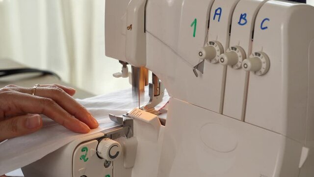 Seamstress making edge on fabric with Over Lock Machine
