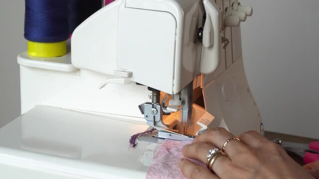 Overlock machine closeup. Asian Seamstress close-up hands.