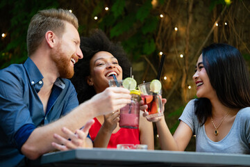 Friends having a great time in cafe, smiling and drinking cocktails enjoying together.