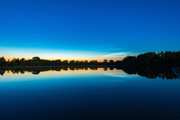 Fototapeta na wymiar Leuchtende Nachtwolken über einem See in Deutschland