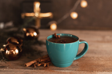 Cup of hot cocoa or hot chocolate on knitted background with fir tree and snow effect, traditional beverage for winter time