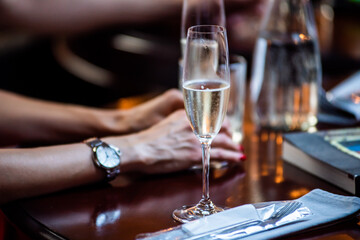 Glass of champagne on the table in a dark restaurant