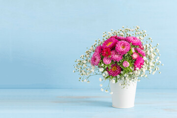 Bouquet of decorative chrysanthemums on blue wooden background with copy space.