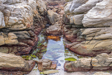 A small clear seaside pool between large rocks