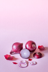 Fresh red onion on a pink background, close-up, copy space.