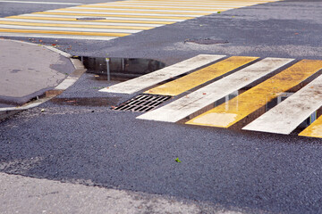 White and yellow pedestrian crossing in a puddle