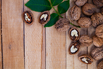 Walnuts and leaves on a wooden table.