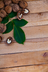 Walnuts and leaves on a wooden table.