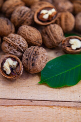 Walnuts and leaves on a wooden table.
