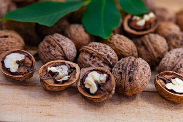 Walnuts and leaves on a wooden table.