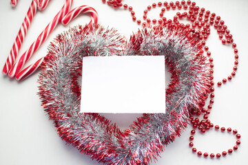 Christmas toys and sweets for Christmas on a white background. space for text. red and white Christmas candies are placed on garlands
