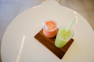 Top view of Red and green colored fruit healthy juices on a wooden tray