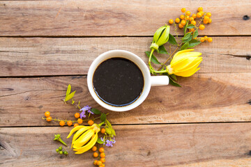 hot coffee with yellow flowers ylang ylang  of lifestyle in autumn season arrangement flat lay style on background white wooden
