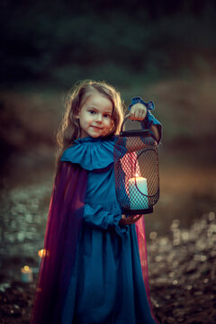 Girl in dress with lantern in a dark forest