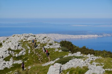 Velebit National Park, Dinaric Mountains, Croatia - circa July 2020: The beautiful Premuziceva Staza mountain path overlooking the Adriatic Sea and islands. Silhouettes of people on viewpoint.