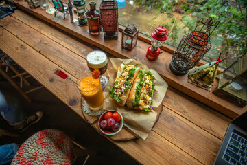 Jeju City,South Korea-July 2019: Baguette sandwiches and two glasses of juicess on a wooden table with vintage lamp decorations