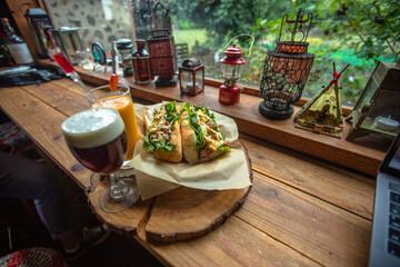 Jeju City,South Korea-July 2019: Two baguette sandwiches and juice drinks on a wooden table with vintage oil lamp decorations beside the window