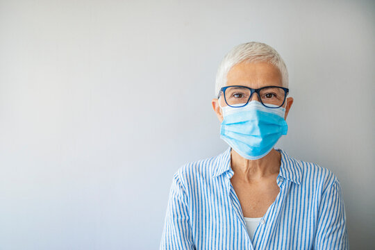 Mature caucasian female wearing face mask during Covid-19 pandemic outbreak. Senior woman uses masks to prevent covid-19, maintaining social distance.