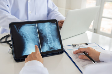 doctor diagnose spine lumber vertebrae x-ray image on digital tablet for diagnose Herniated disc...