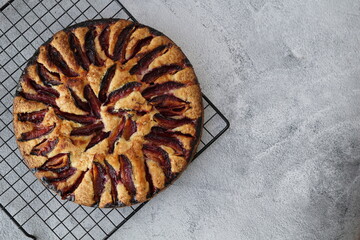 The plum pie on the gray background