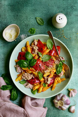 Pasta penne with tuna and vegetables in tomato sauce. Top view with copy space.
