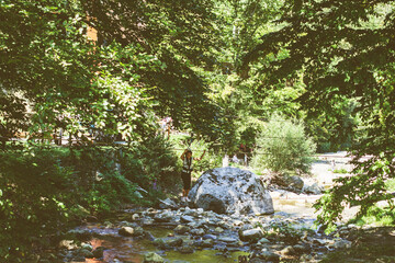 Brave little girl in the forest adventure park, wearing helmet and safety equipment at amusement center for children outdoor
