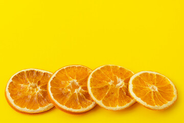 Dried orange slices on a bright yellow background. Close-up, place for your text, copy space