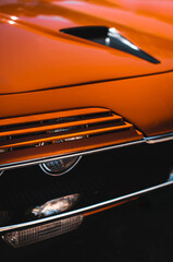 Headlight of a orange newtimer sport car detail	
