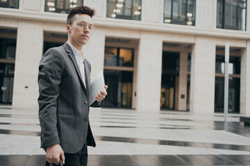 business man goes to work in the office a man of European appearance, waits a couple of minutes, stylish haircut, glasses, gray business suit from a fashion store