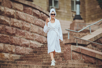 Fototapeta na wymiar Charming girl in a bathrobe on a city street 