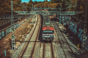 Tren de cercanías pasando por debajo de un paso a nivel