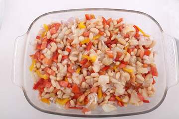 Fototapeta na wymiar fresh summer salad with beans, cod, tomato and onions