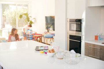 Ingredients for Cake Baking On Kitchen Counter With Mother And Son In Background