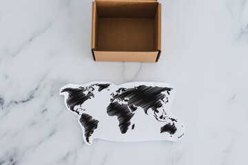 miniature postal parcel next to world map, global trade and worldwide deliveries