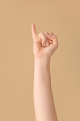 Hand showing letter I on color background. Sign language alphabet
