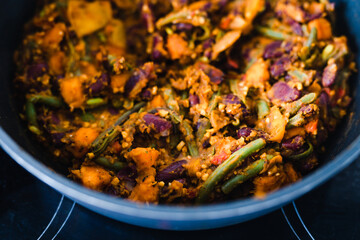 plant-based food, vegan mixed vegetables and red kidney beans getting sauteed in pan on stove