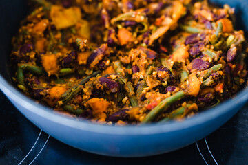 plant-based food, vegan mixed vegetables and red kidney beans getting sauteed in pan on stove