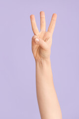 Hand showing letter W on color background. Sign language alphabet