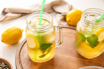 Mason jars of tasty cold ice tea on table