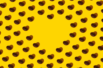 Creative bright collage of real macro photos of selected coffee beans on a yellow background with a hard shadow in the shape of a heart with a place for inscription.
