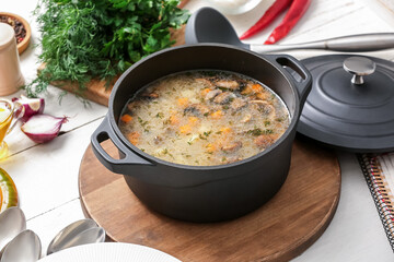 Pot of tasty rice soup on table