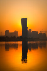 Fototapeta na wymiar Sunrise Sky view background behind capital gate tower of Abu Dhabi, Skyscrapers in Capital city of United Arab Emirates