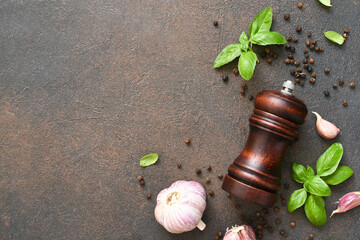 Salt, peppercorns, fresh basil on a concrete background. View from above.