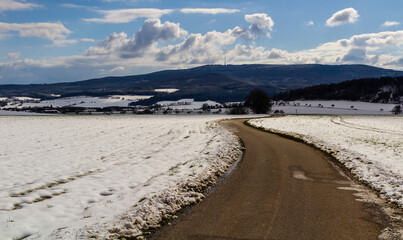 Hill Klet in winter. Czech landscape with road and snow field
