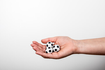 Three miniature soccer ball in woman's palm. Popular sport, entertainment, business and lifestyle concept