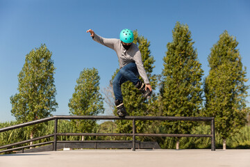 male roller skater with protective helmet and coronavirus prevention mask does a trick in a skate...