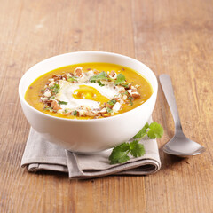 pumpkin soup with cream on wood background